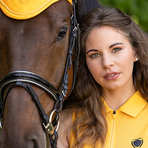 Reiterin mit braunem Pferd in gelber Reitkleidung der Covalliero Sports Collection