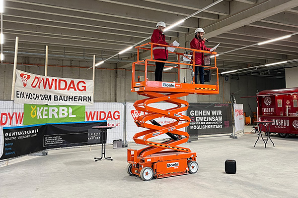 Eine orange Hebebühne auf der Baustelle des Logistikzentrums in Ampfing